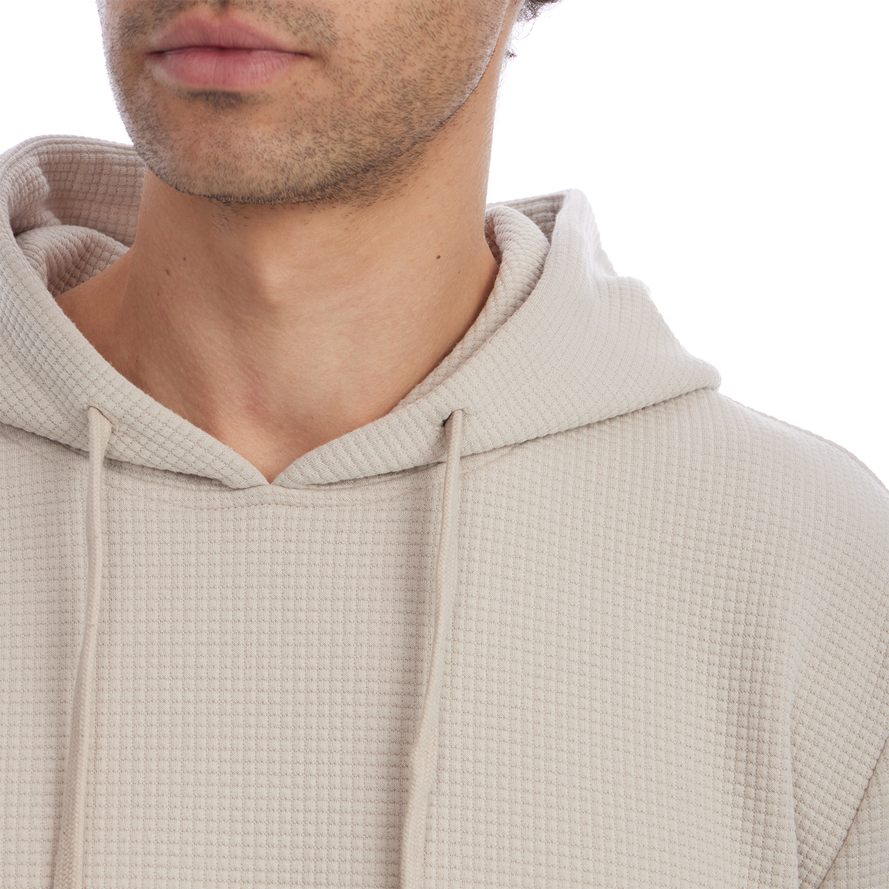 Close-up of a person wearing a beige hooded garment on a white background