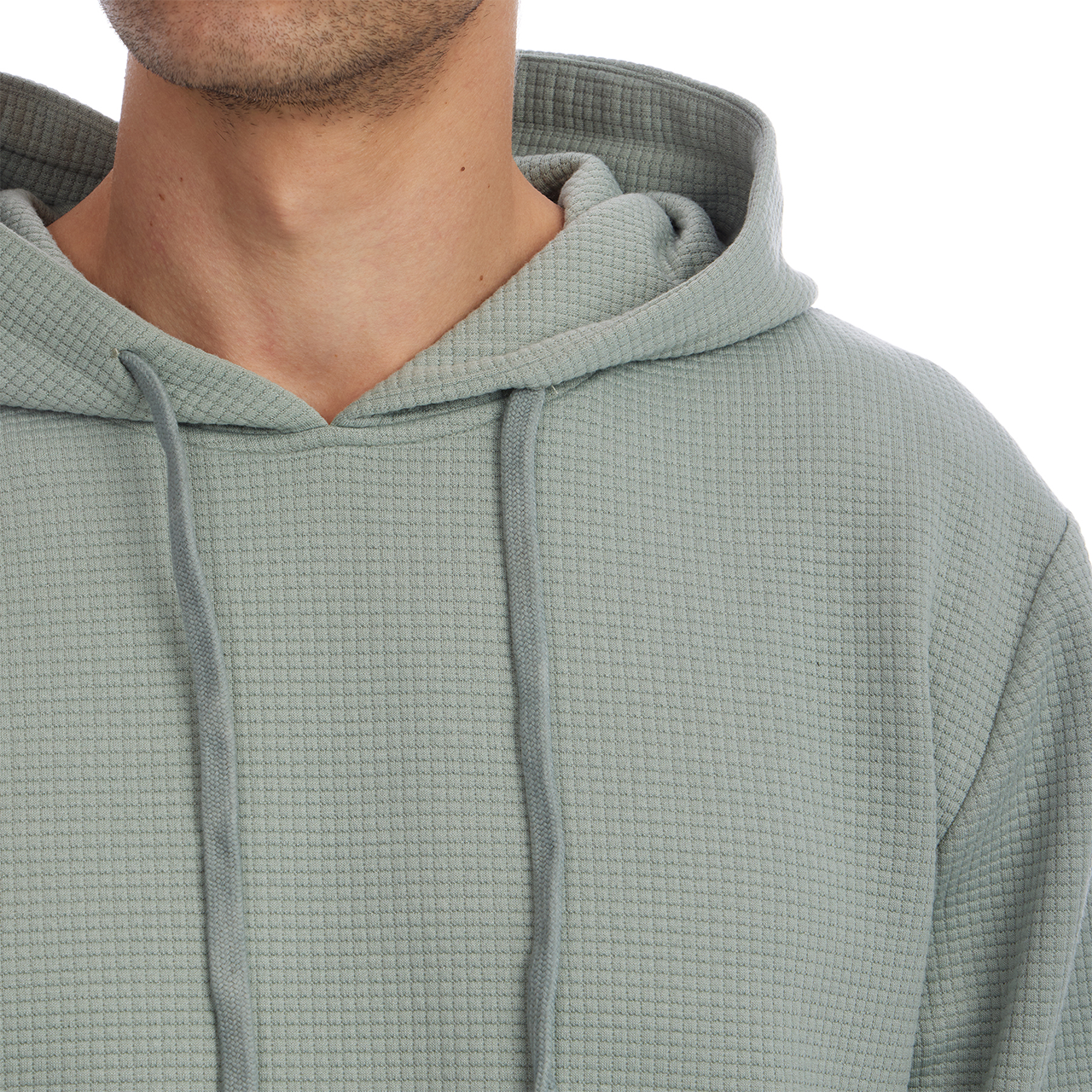 Close-up of a person wearing a textured green hoodie on a white background