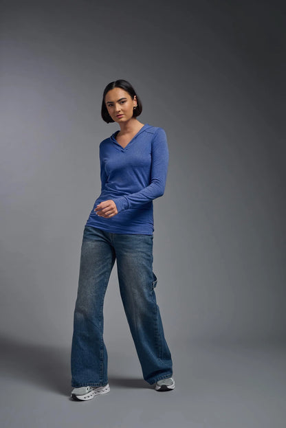 Person wearing a blue long-sleeve shirt and jeans on a gray background