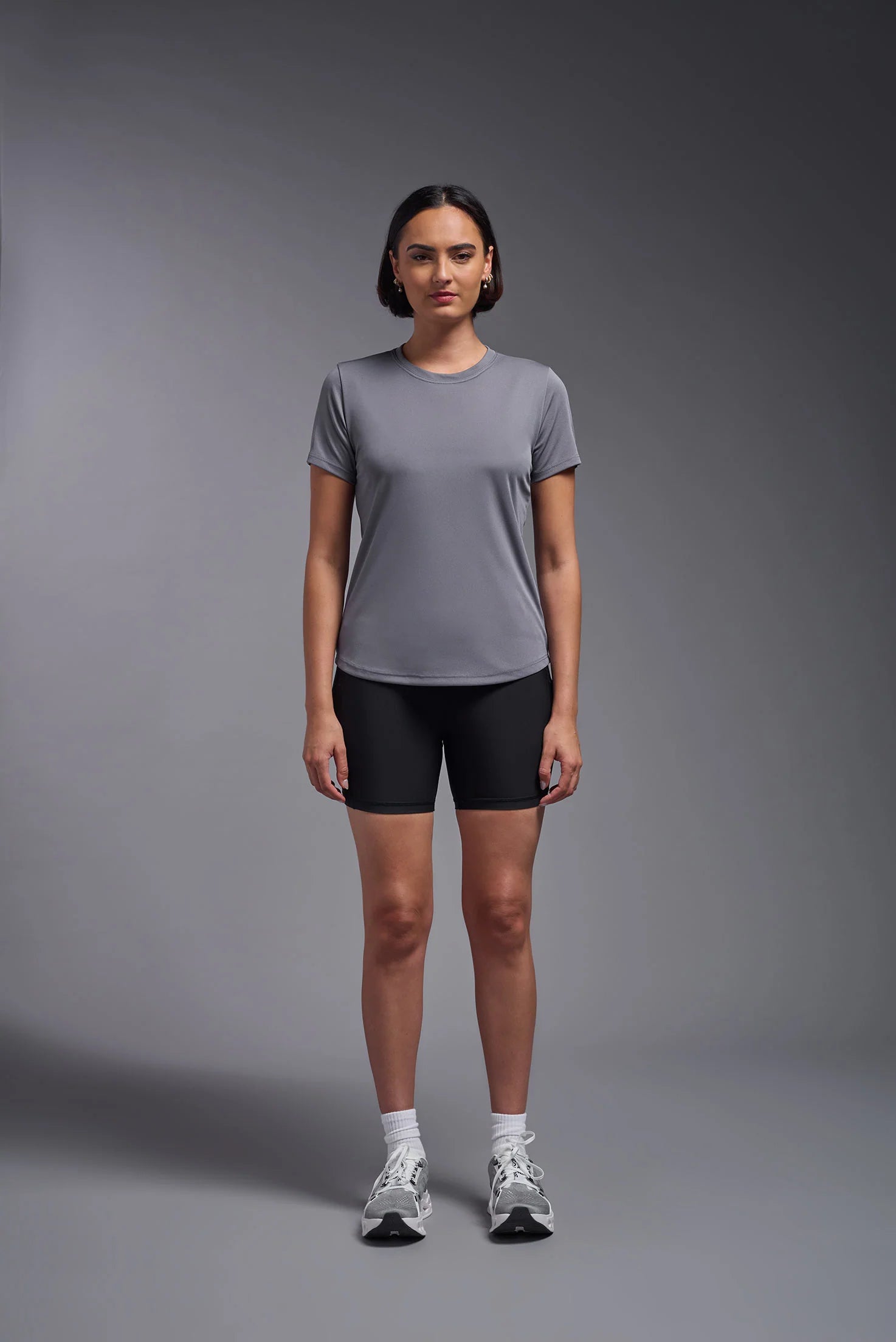 Person wearing a gray t-shirt and black shorts on a gray background