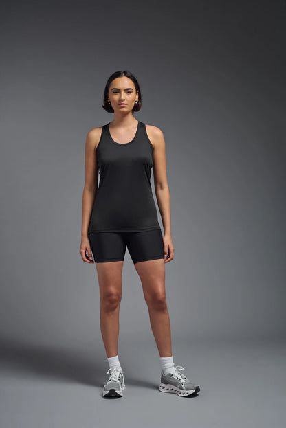 Woman wearing a black athletic outfit on a gray background