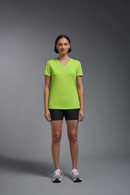 Person wearing a bright green t-shirt and black shorts on a gray background