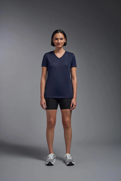 Woman wearing a navy blue t-shirt and black shorts on a gray background