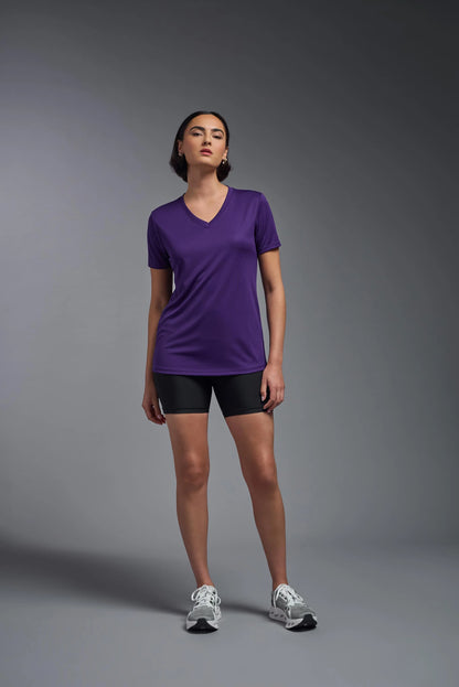 Person wearing a purple shirt and black shorts on a gray background