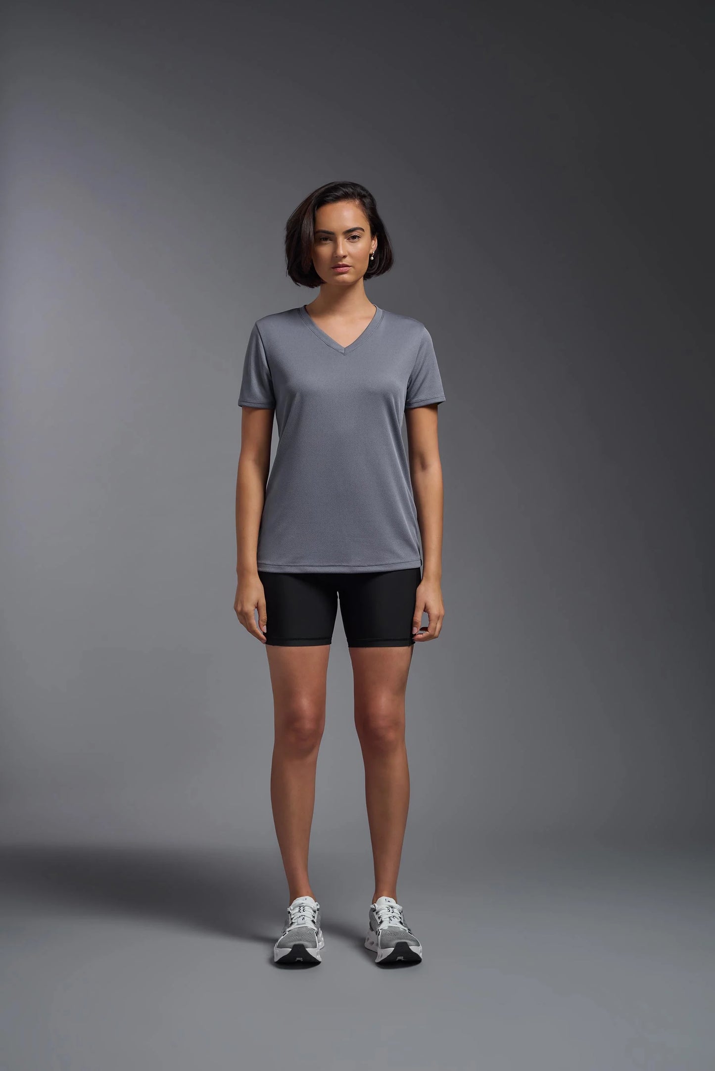 Person wearing a gray t-shirt and black shorts on a gray background