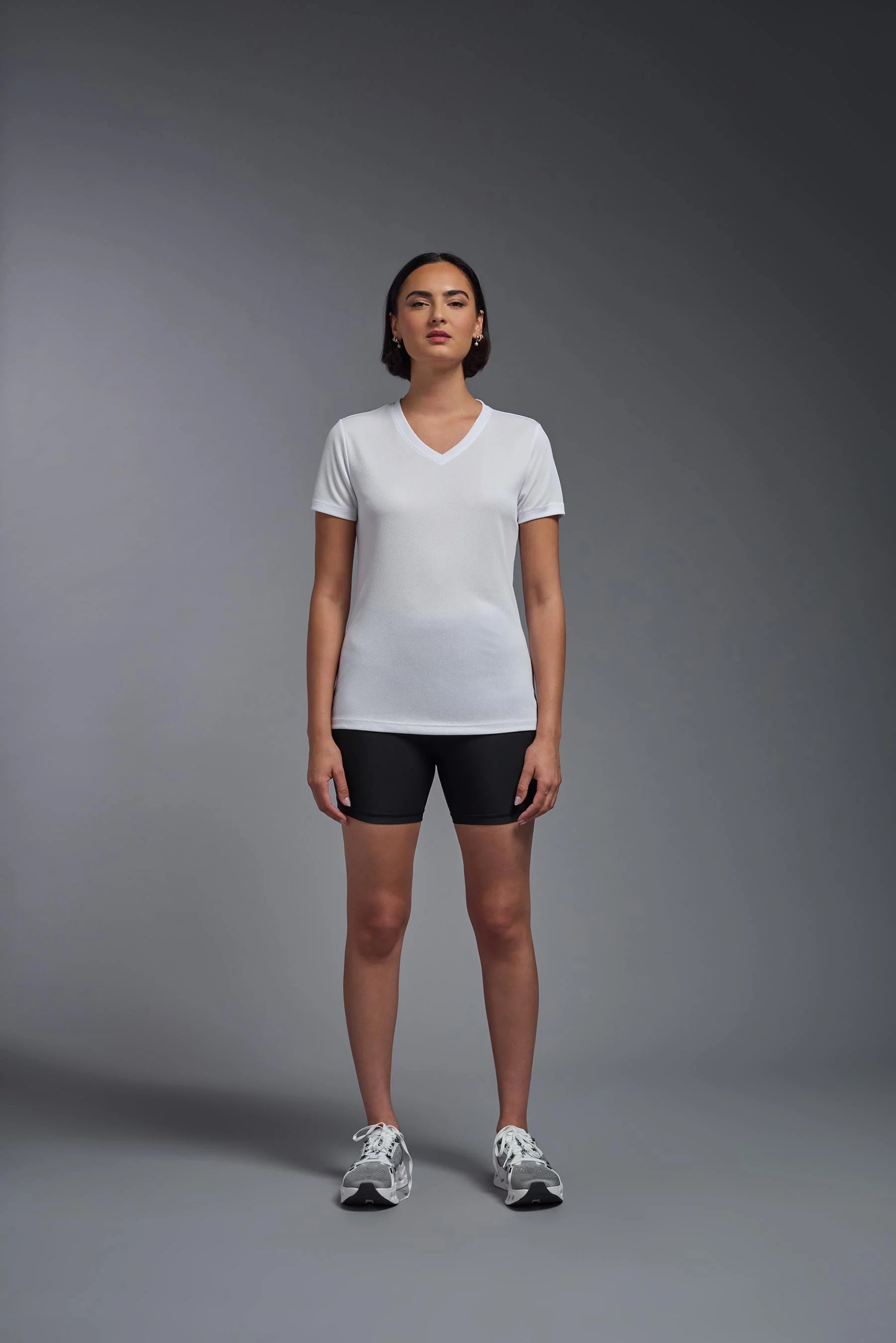 Person wearing a white t-shirt and black shorts on a gray background