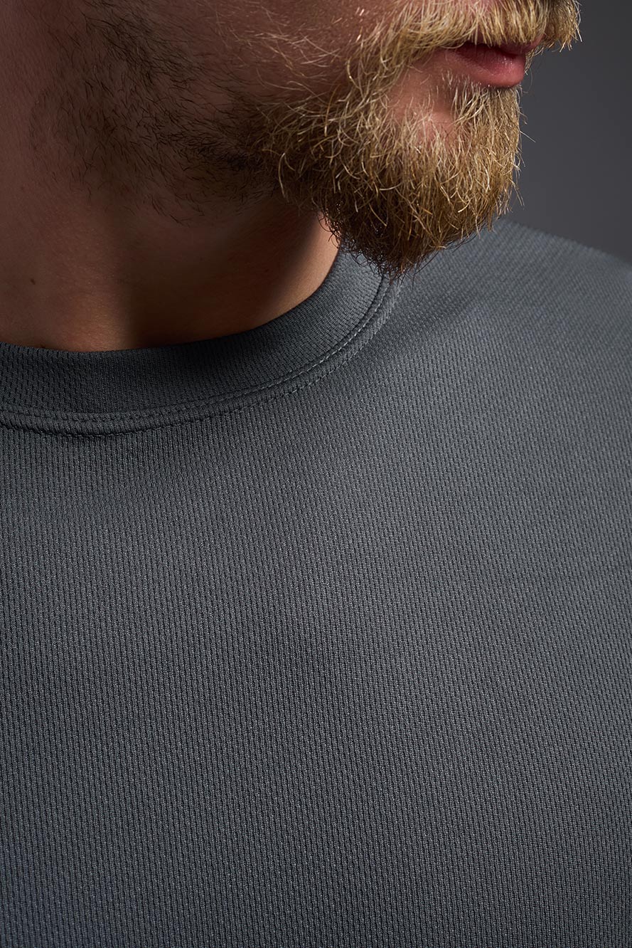 Close-up of a person wearing a dark gray sweatshirt with a blurred background