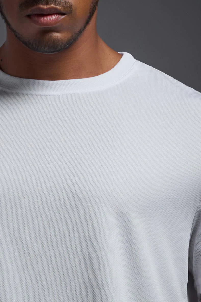 Close-up of a person wearing a light gray long-sleeve shirt against a dark background