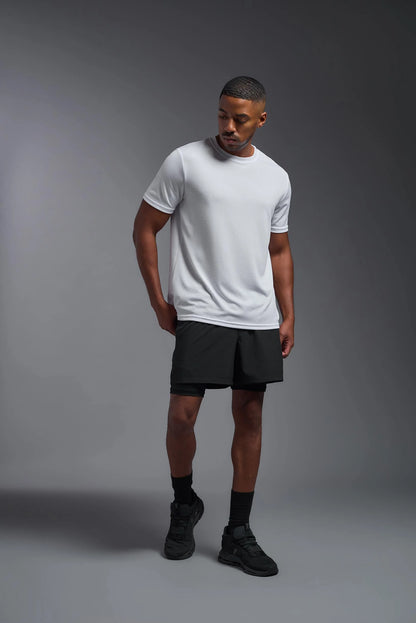 Man wearing a white t-shirt and black shorts on a gray background