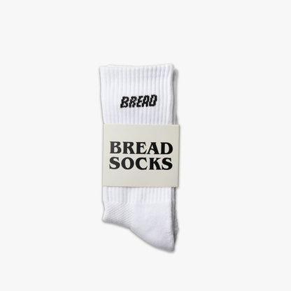 White ribbed crew socks with bold black “BREAD” logo on the cuff