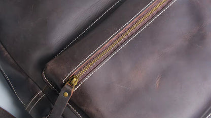 Close-up of a brown leather bag with a gold zipper.