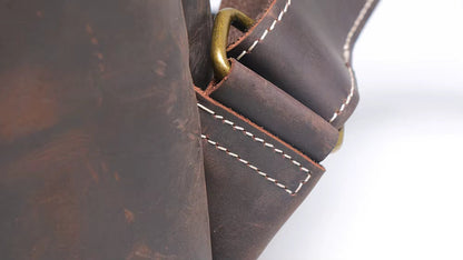 Close-up of a brown leather bag with a gold buckle on a white background