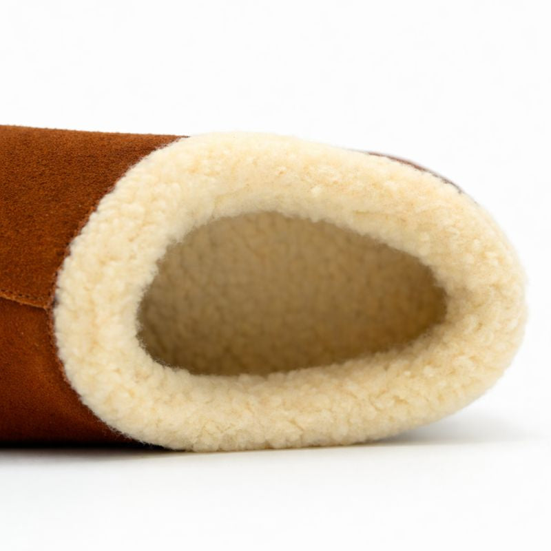 Close-up of a brown slipper with beige interior on a white background