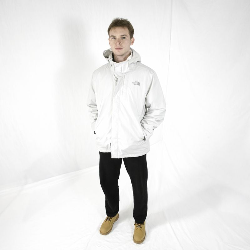 Person wearing a white jacket with a brand logo on a white background
