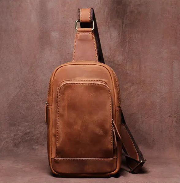 Brown leather crossbody sling bag front view with top loop and shoulder strap