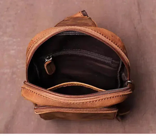 Brown leather crossbody pack, open top with zip pocket and inner organizer detail