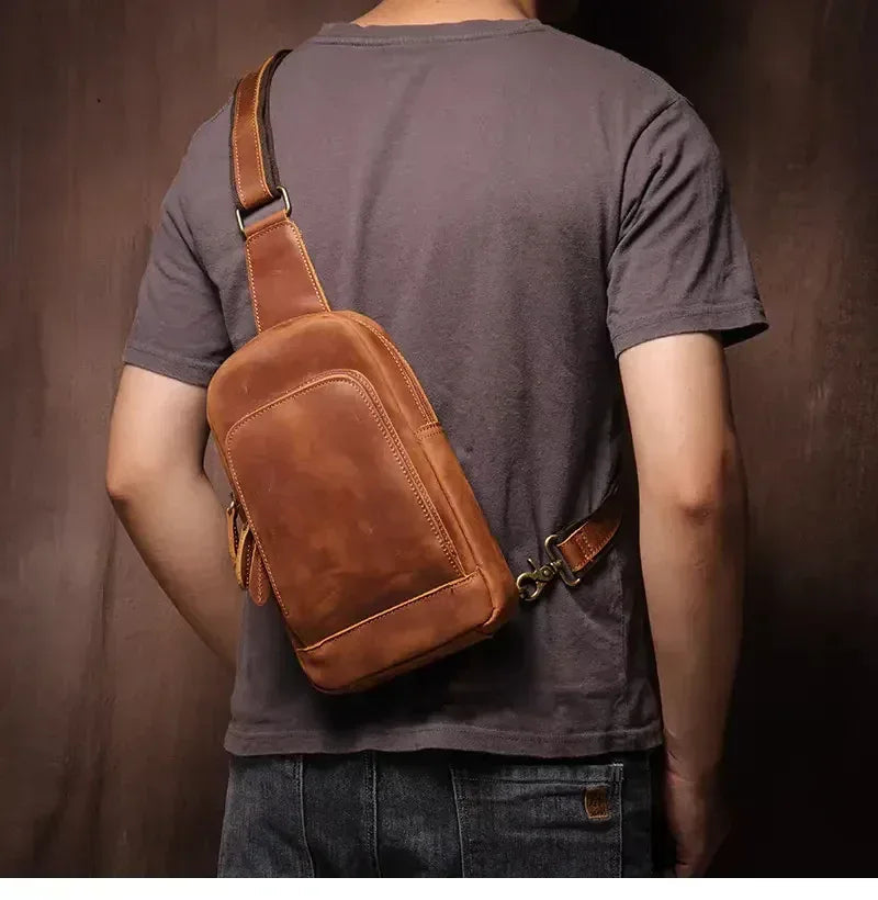 Brown leather crossbody pack worn on body with adjustable shoulder strap