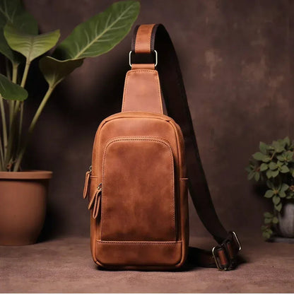 Brown leather crossbody sling bag with front zipper pocket and adjustable shoulder strap