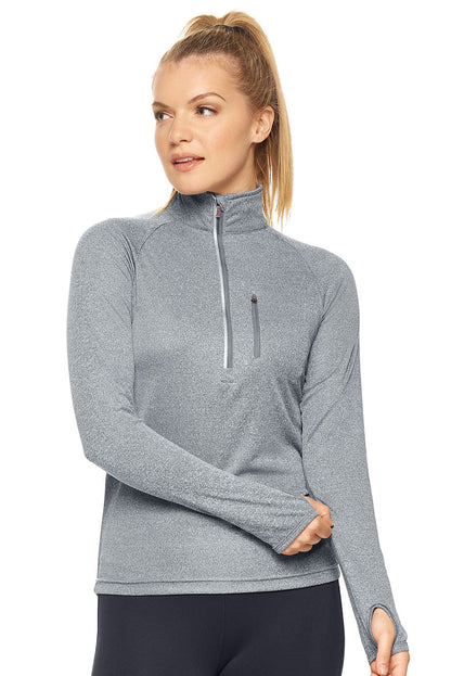 Woman wearing a gray long-sleeve athletic top with a quarter zip on a white background