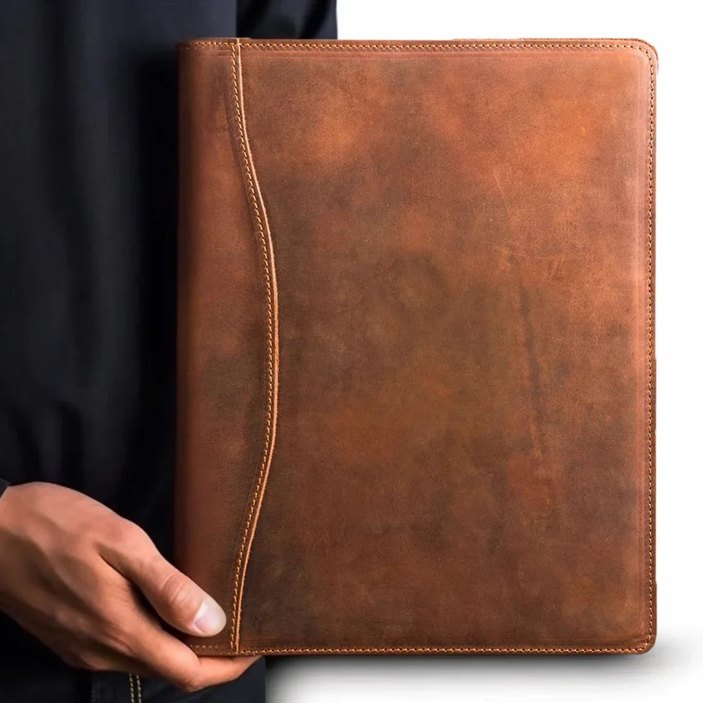 Brown leather padfolio close-up with hand holding, stitched edges