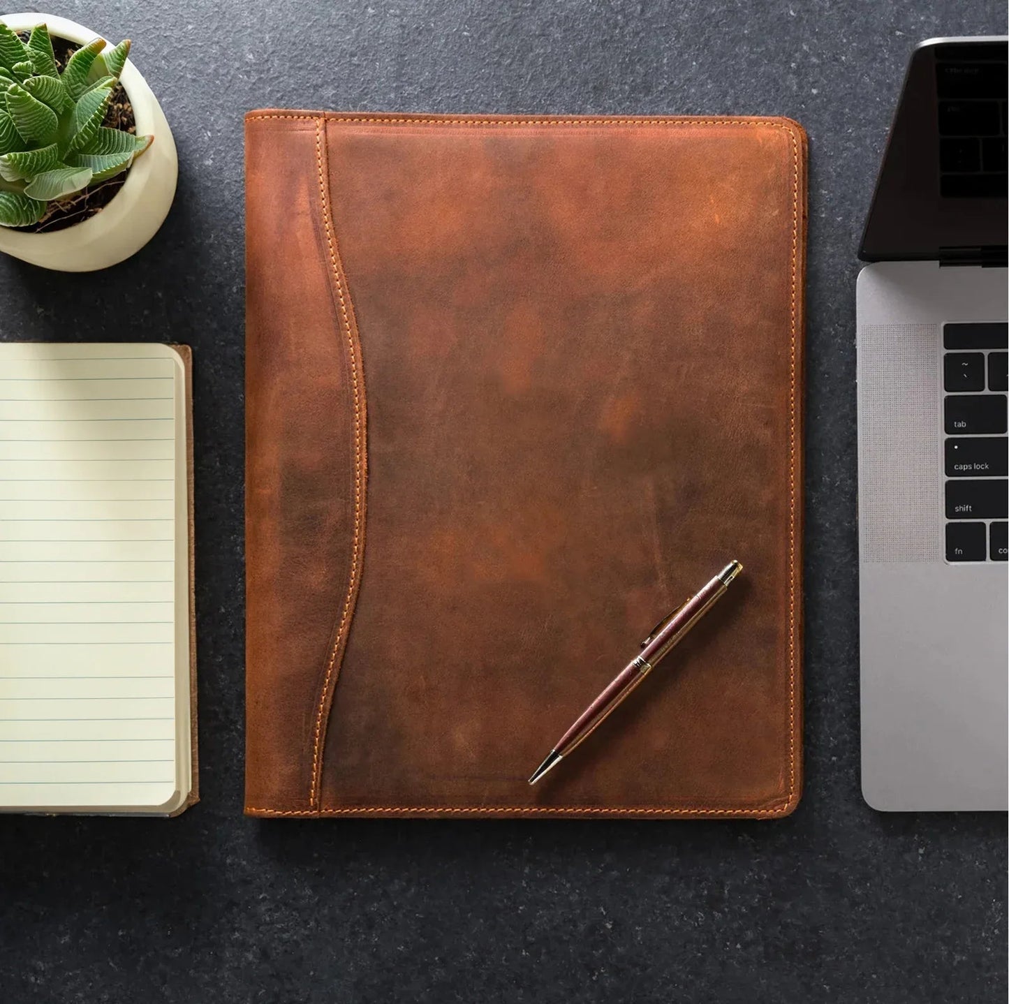 Brown leather padfolio with pen, stitched border and front cover
