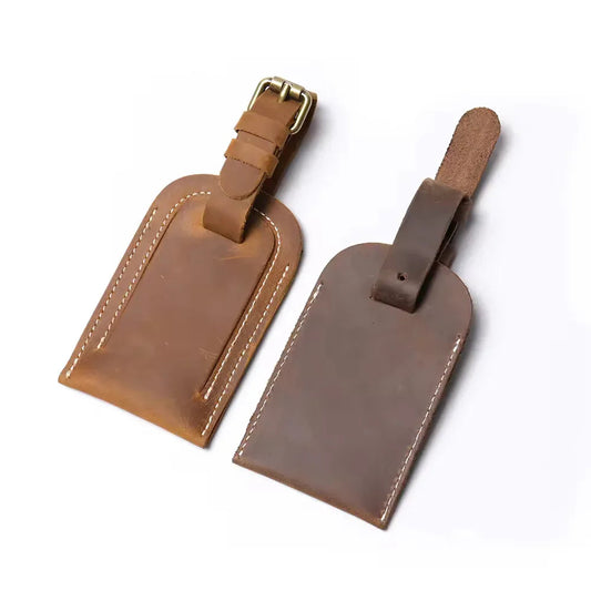 Full grain leather luggage tag set in brown with metal buckles and stitched edges.