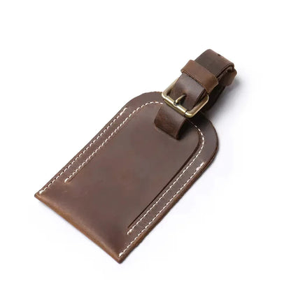 Dark brown full grain leather luggage tag with metal buckle and double-row stitching.