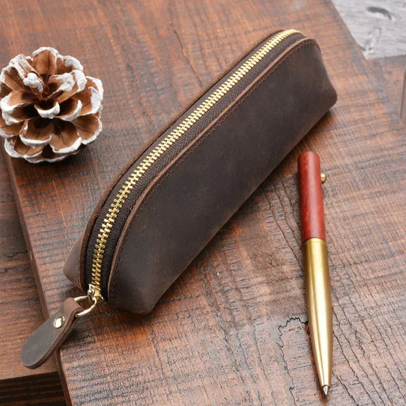 Dark brown leather makeup pouch with gold zipper and wrist strap