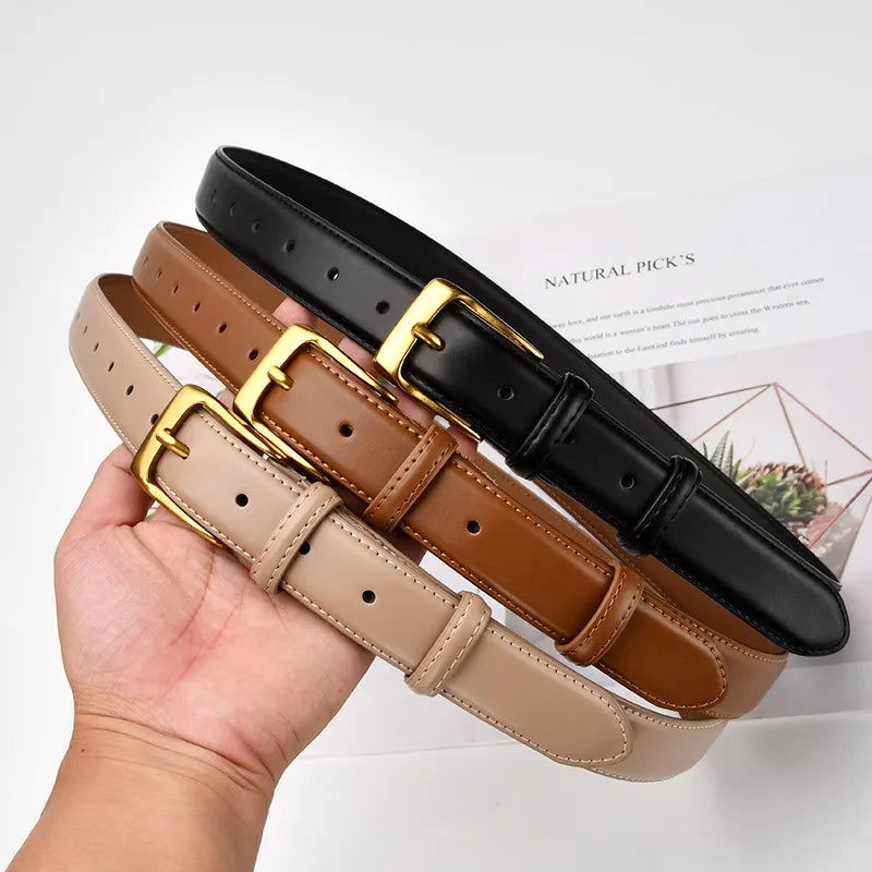Women's Genuine Leather Belt khaki, brown, and black held in a hand