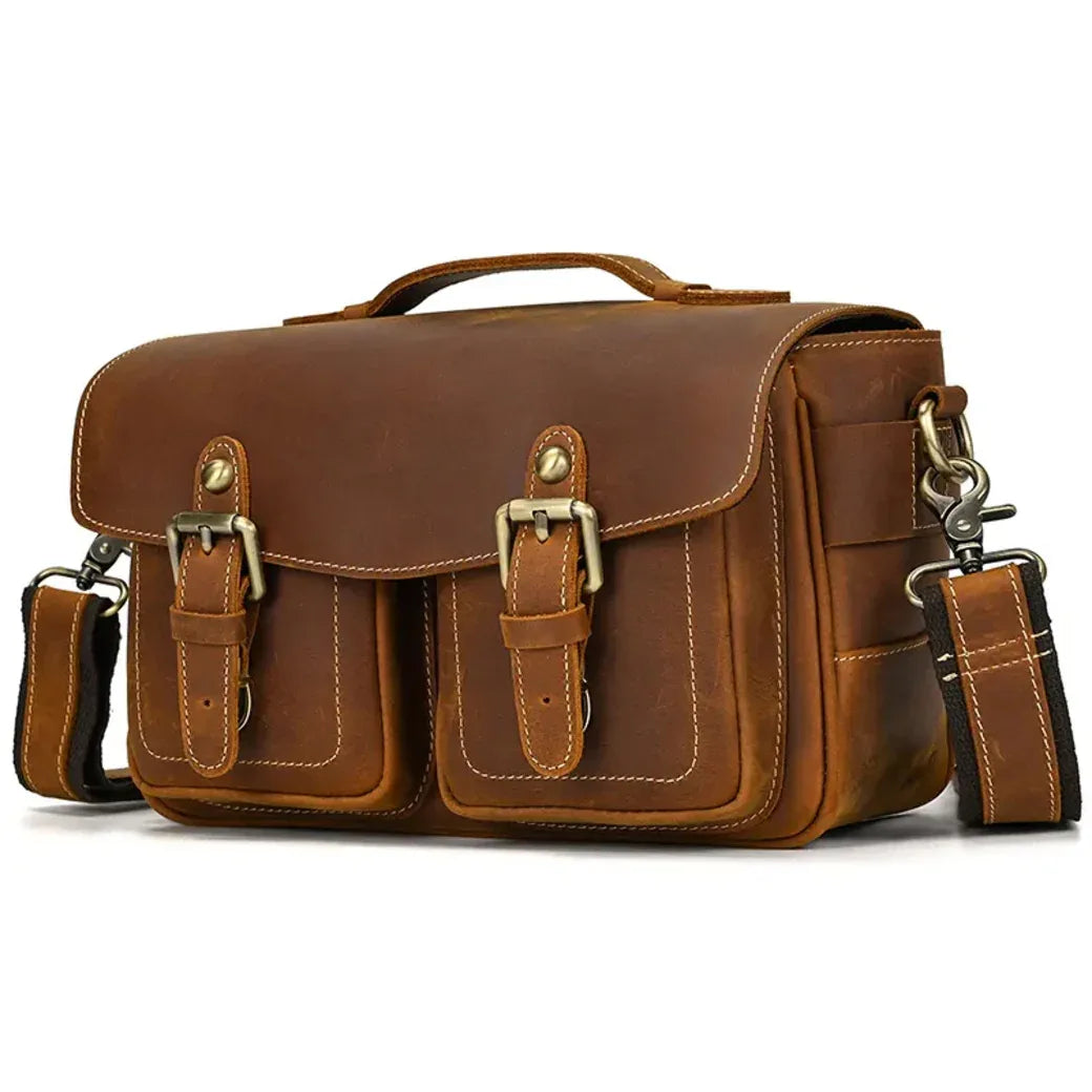 Brown leather messenger bag with top handle, front flap, and two buckle straps