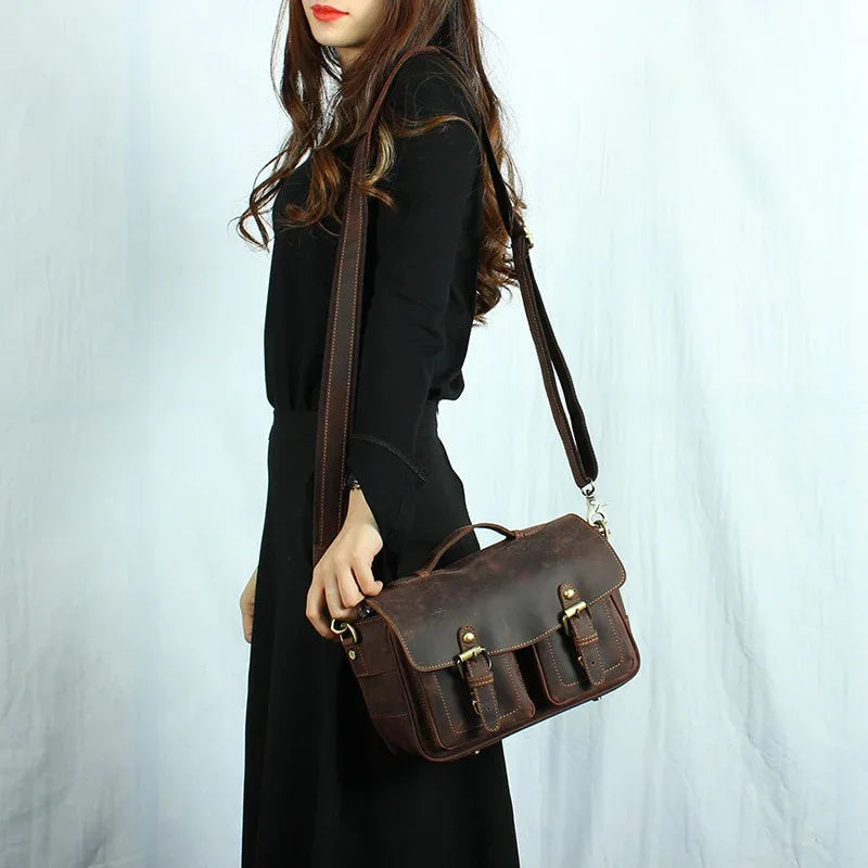 Brown leather crossbody camera messenger bag with flap, front buckle, and shoulder strap