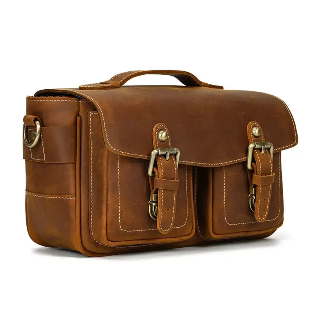 Brown leather camera messenger bag with front latch, stitched panels, and side carrying handle