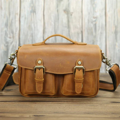 Tan leather camera messenger bag with front buckle straps and crossbody shoulder strap