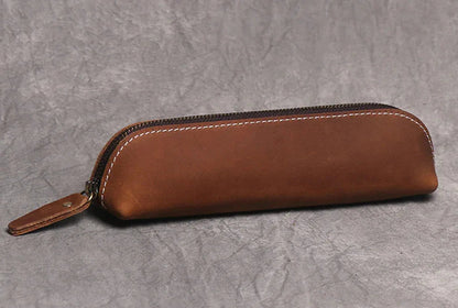 Brown leather makeup pouch with smooth finish, zipper closure and wrist strap