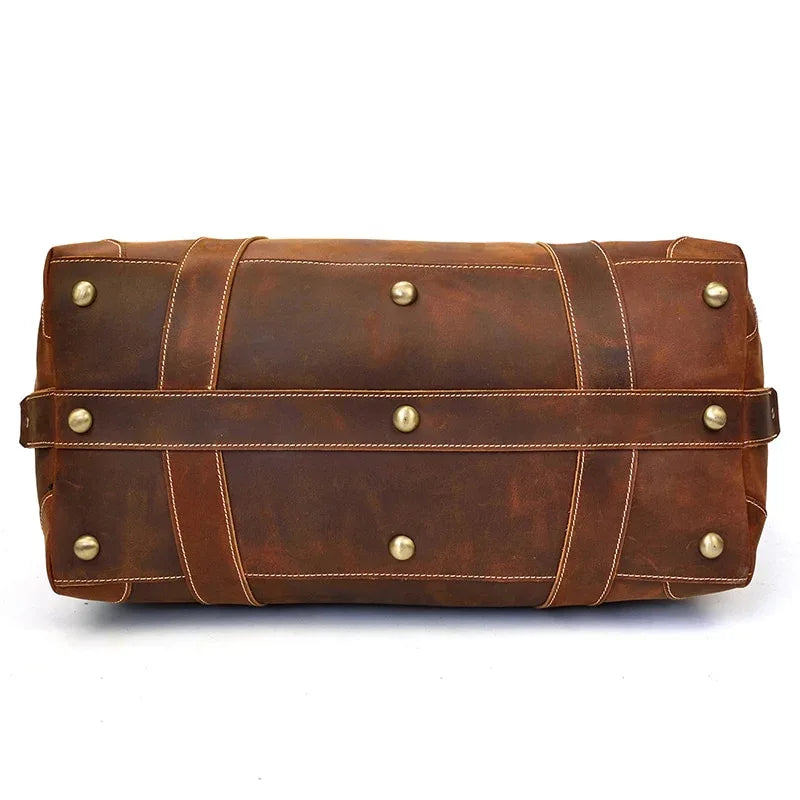 Brown vintage leather duffle bag with front strap and brass stud details