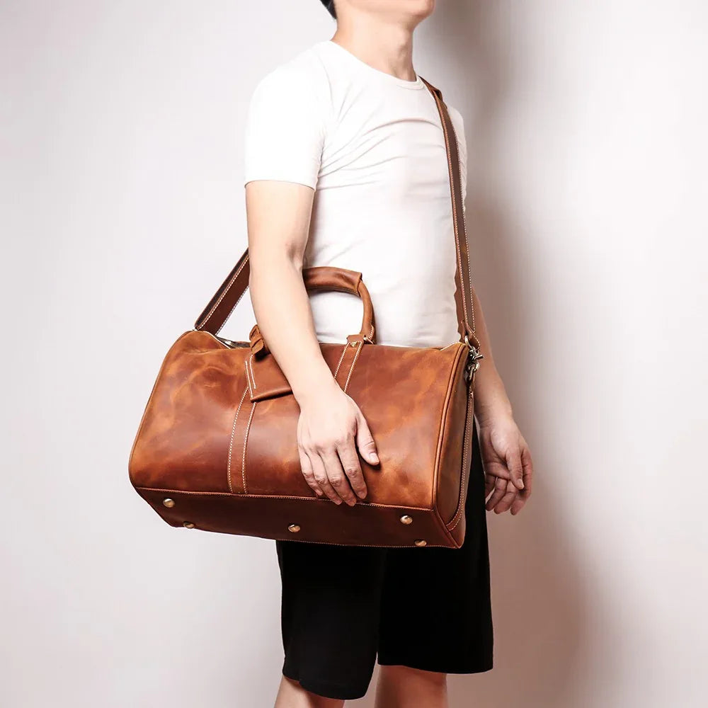 Small leather duffle bag in brown, with top handles and front zipper pocket
