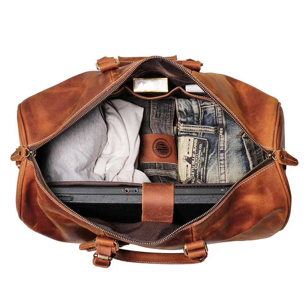 Small leather duffle bag open, showing interior pockets and zip top in brown