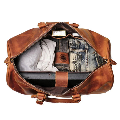 Small leather duffle bag open, showing interior pockets and zip top in brown