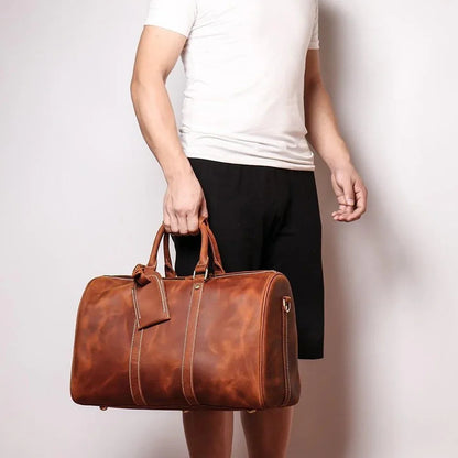 Small leather duffle bag in brown with double handles and zip closure