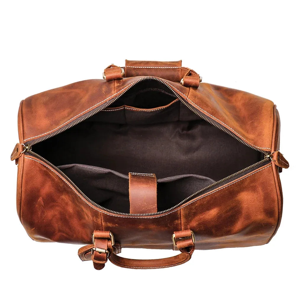 Small leather duffle bag open, dark interior with zip opening and brown straps
