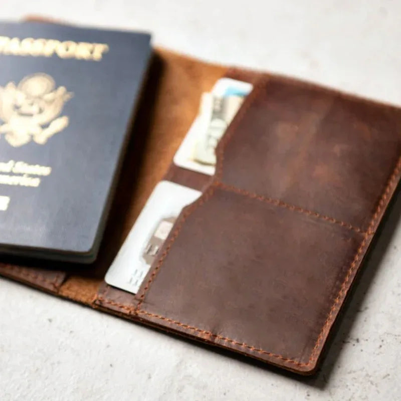 Brown leather passport cover open, showing inner pocket and stitched lining.