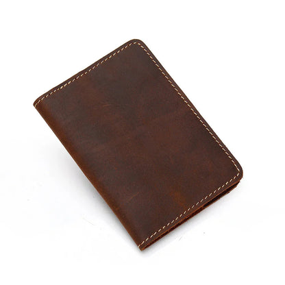 Brown leather passport cover, closed angled view with contrast stitching.