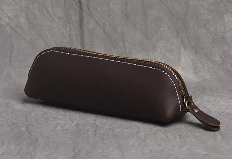 Dark brown leather makeup pouch with zipper and leather pull tab, closed