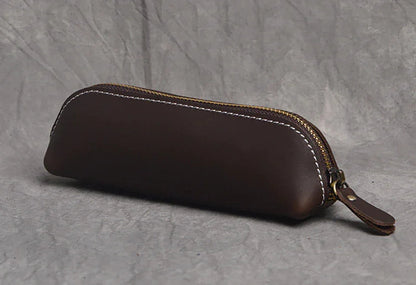 Dark brown leather makeup pouch with zipper and leather pull tab, closed