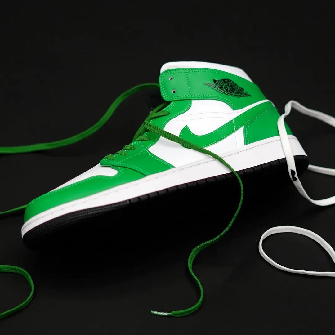 Green and white sneaker with a black background