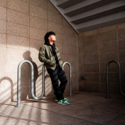 Person leaning against a wall in an urban setting