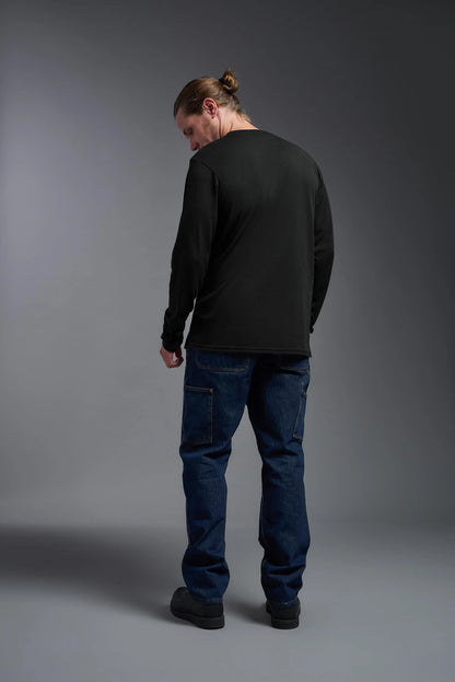 Person wearing a black long-sleeve shirt and blue jeans against a gray background