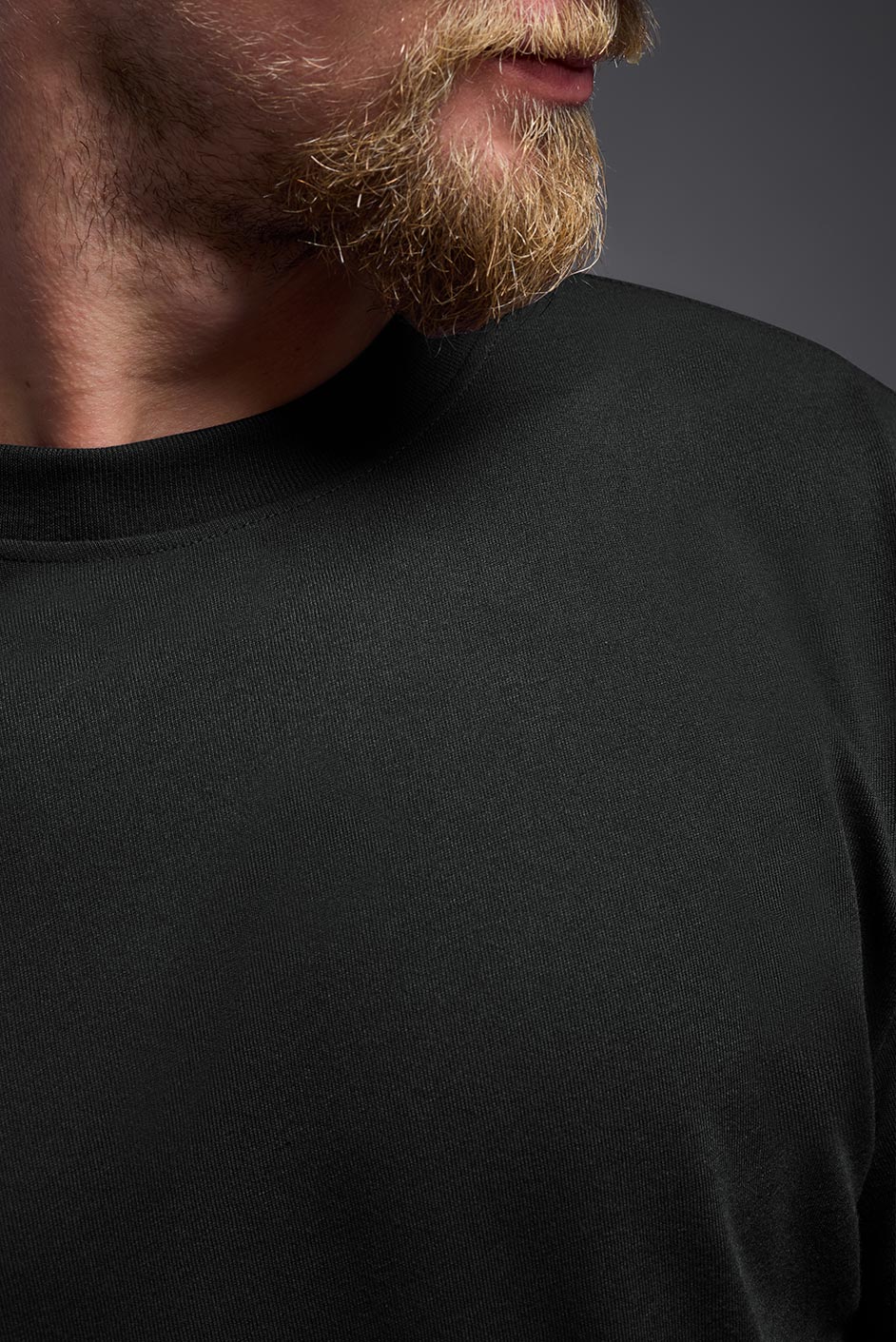Close-up of a person wearing a black shirt against a dark background