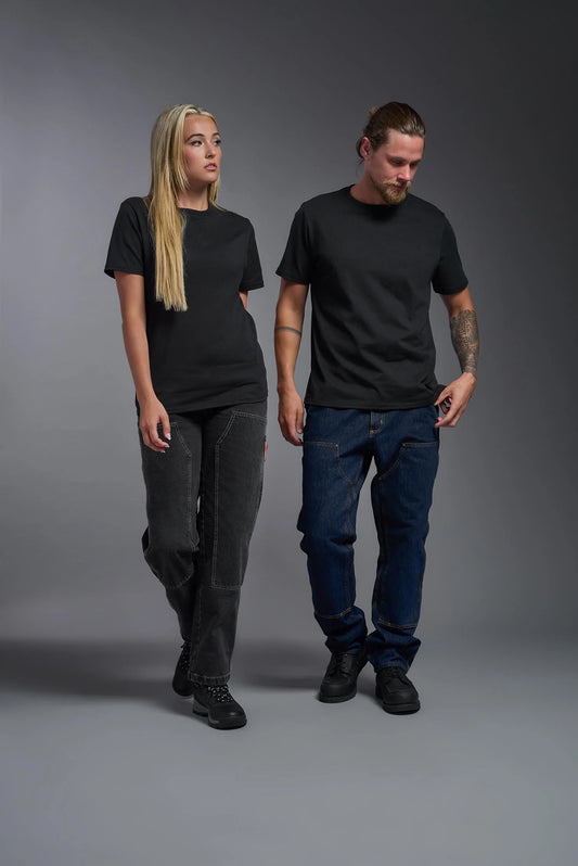 Two people wearing black t-shirts and dark pants on a gray background