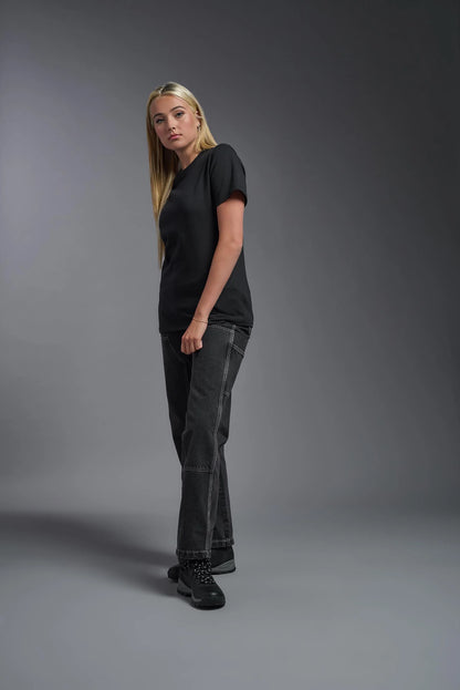 Person wearing a black t-shirt and dark jeans against a gray background